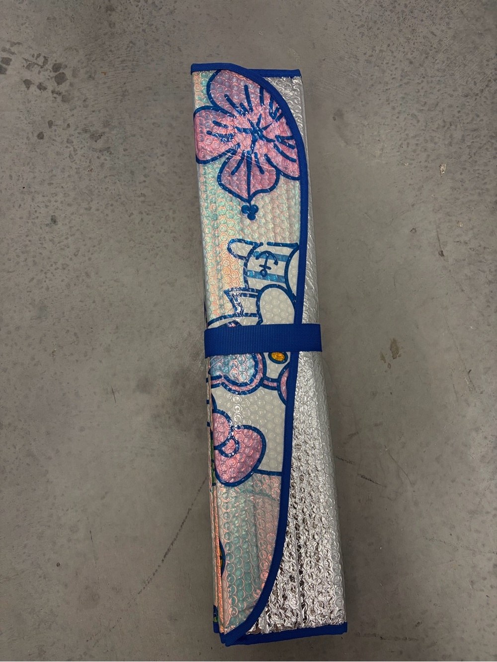 Se trata de un parasol plegable para el parabrisas del auto con hello kitty